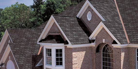 brick 2-story house with asphalt shingle roofing