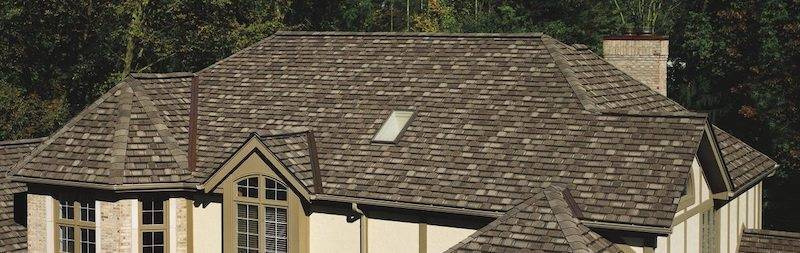 Tan house with brown asphalt shingle roofing