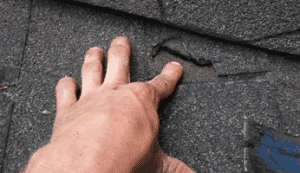 hand pointing to roof damage